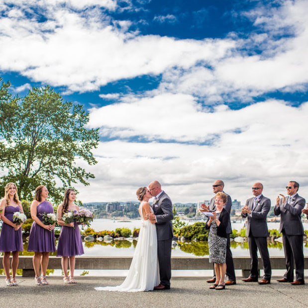 Bride and groom kissing at waterfront wedding ceremony, Victoria BC