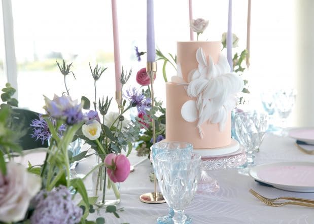 Peach cake with white circles on a table set for a wedding