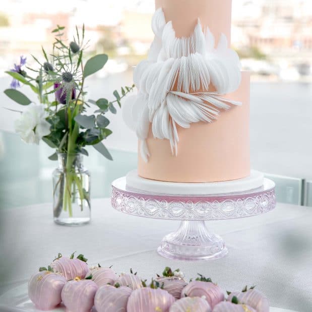 Two tier peach wedding cake with pink chocolate dipped strawberries Inn at Laurel Point