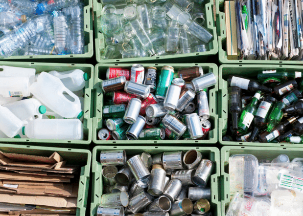 overhead view of sorted recycling in bins: cans, glass bottle, plastic bottles, cardboard