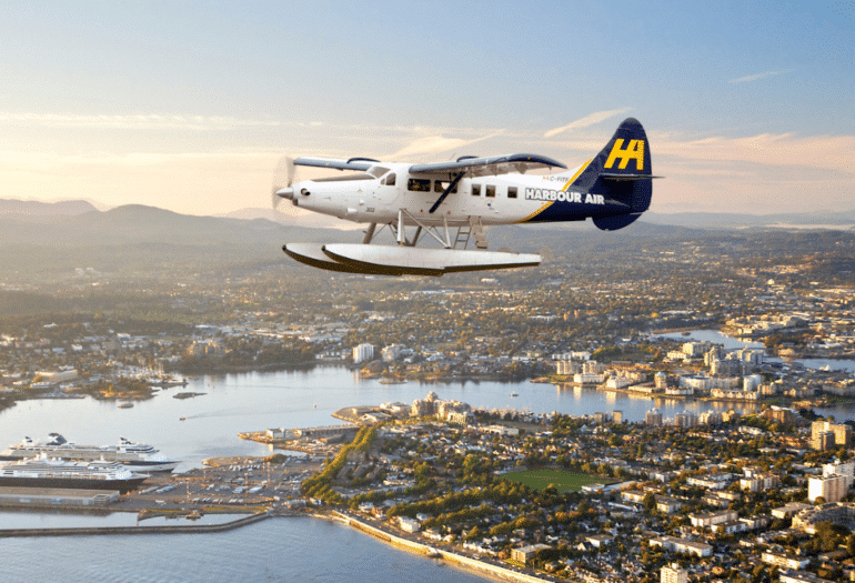 Harbour Air Seaplane flying over Victoria outer harbour and cruise ship terminal