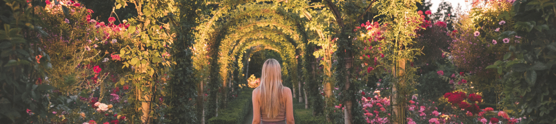 Girl walking under arches at Butchart Gardens
