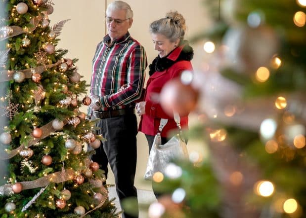 couple admiring christmas tree in marble lobby