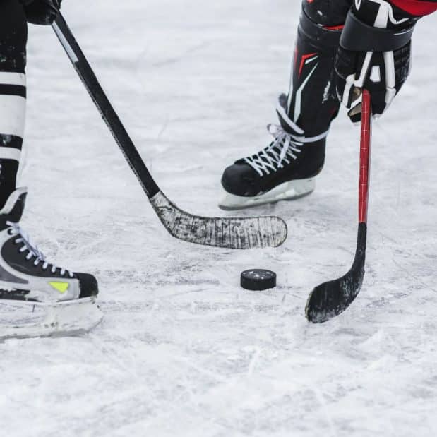 close up of 2 people playing hockey