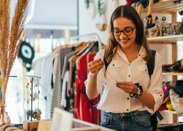 woman shopping in second hand store, looking at a necklace
