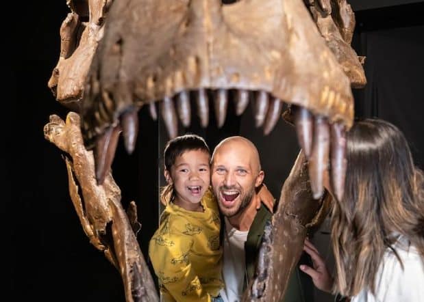 young family inside dinosaur skeleton at key to the city partner dino lab inc