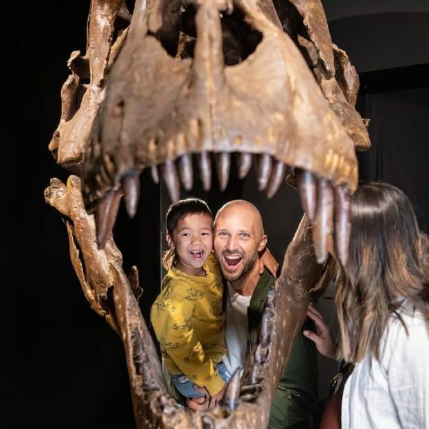 young family inside dinosaur skeleton at key to the city partner dino lab inc