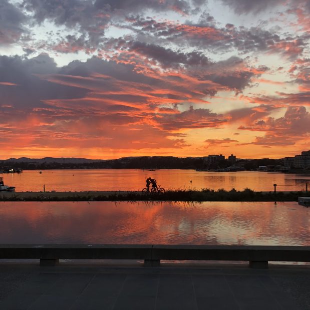 outer harbour sunset with couple on bicycles kissing