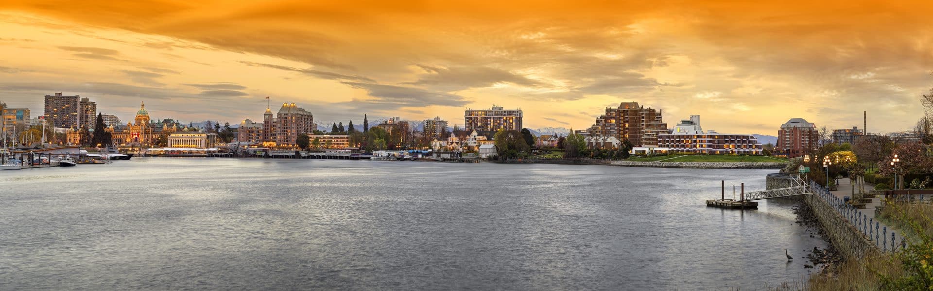 panorama of Victoria inner harbour at sunset with golden clouds