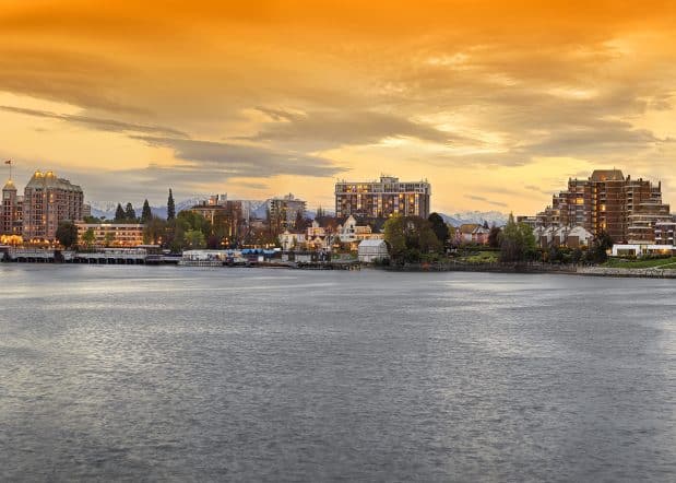 panorama of Victoria inner harbour at sunset with golden clouds