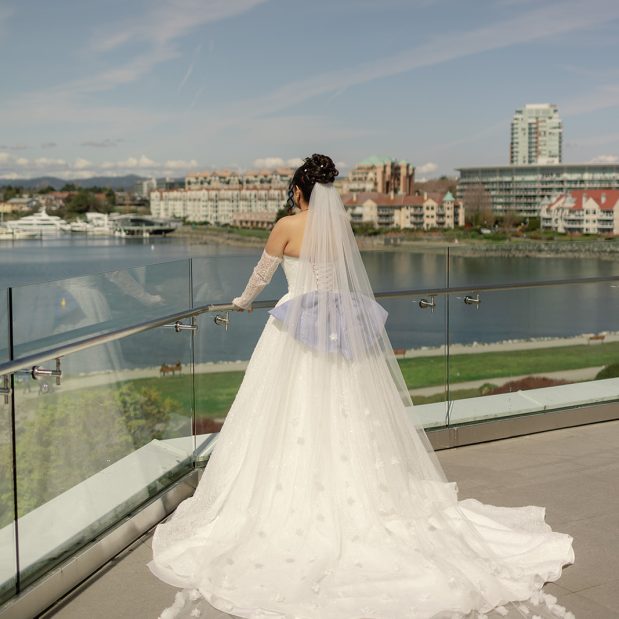 bride in wedding dress on balcony overlooking outer harbour, Picture Credit: Wild Candid Collective
