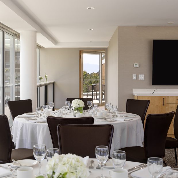 Rogers Suite set in rounds for dinner, looking out the back facing south west, with a hint of balcony and mountains in the background