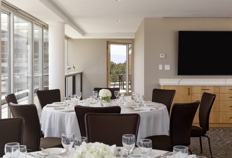 Rogers Suite set in rounds for dinner, looking out the back facing south west, with a hint of balcony and mountains in the background